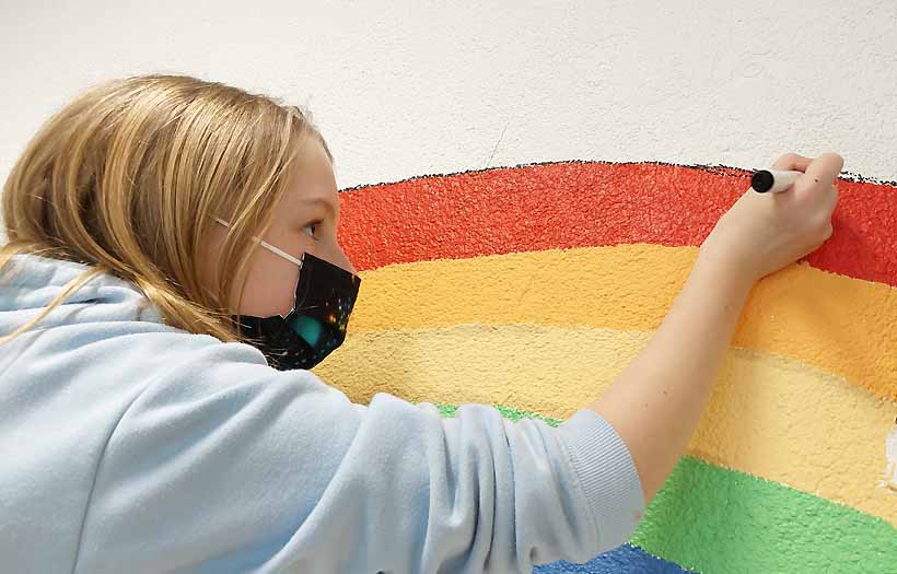 Konzentriert und sehr genau maalt eines der Mädchen der Projektgruppe Gestaltung an ihrem Teil des Wandbildes im Foyer der DPFA-Regenbogen-Schulen Zwickau.