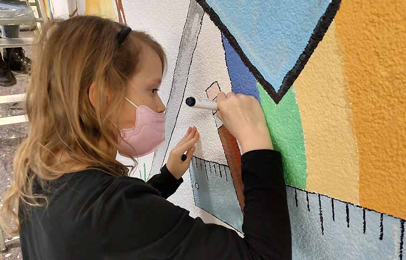 Einfach mitmachen: Ein Mädchen der Prjektgruppe Gestaltung malt geduldigt und konzentriert am Wandbild im Foyer der DPFA-Regenbogen-Schulen Zwickau.