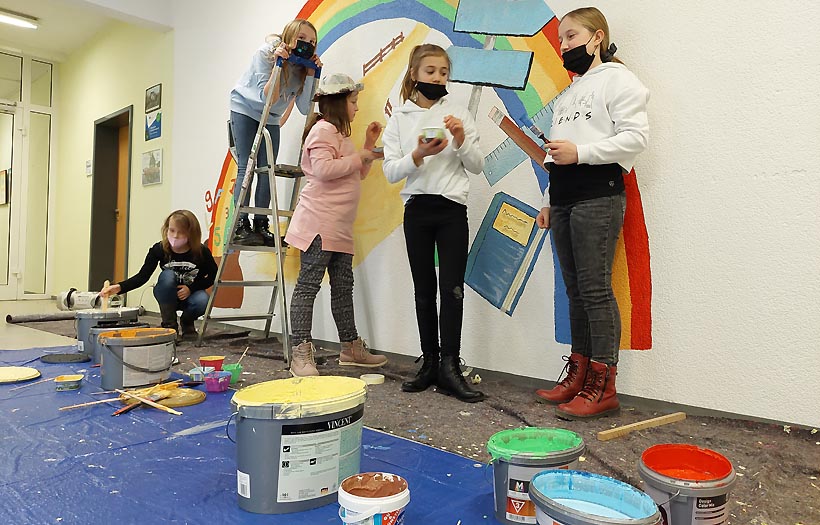Schülerinnen der Projektgruppe Gestaltung tauschen sich über die Vorgehensweise bei der Gestaltung des Wandbildes in ihrer DPFA-Regenbogen-Schule Zwickau aus.
