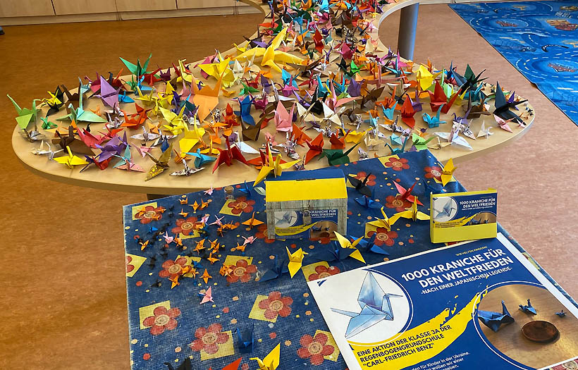 Auf zwei Tischen in der Klasse 3a der DPFA-Regenbogen-Grundschule Zwickau sind die 800 bereits gefalteten Origami-Kraniche zu sehen.