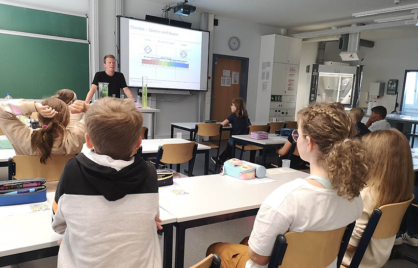 Chemielehrer der DPFA-Regenbogen-Schulen Zwickau fragt die Klasse nach Beispielen für Säuren im Haushalt.